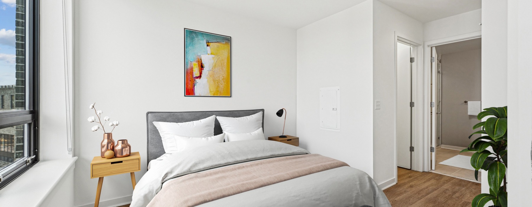 bedroom with large windows, wood flooring and opens into the bathroom